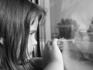 una niña triste en una ventana