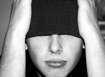 Imagen de un joven adolescente con los ojos tapados por su gorro