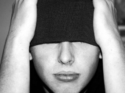 Imagen de un joven adolescente con los ojos tapados por su gorro